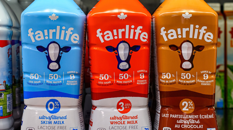 Plastic bottles of Fairlife Skim Milk, Fairlife Whole Milk, and Fairlife Chocolate Milk at a grocery store