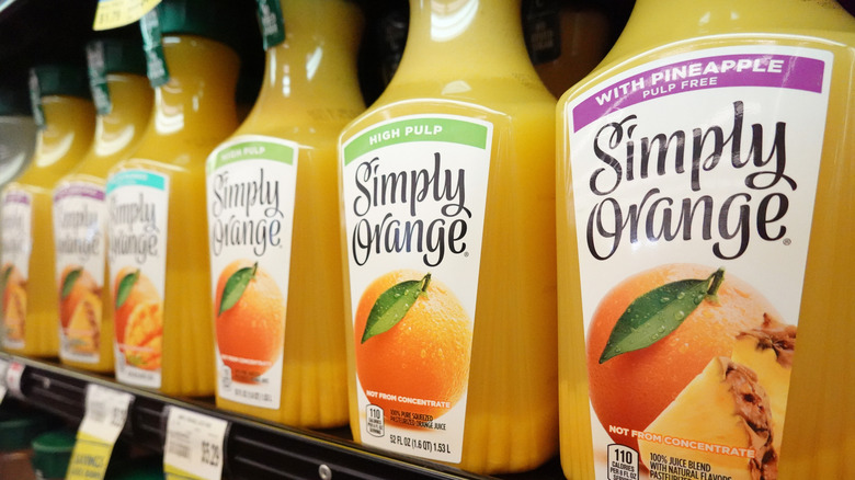 Different styles of Simply Orange Juice lined up on a grocery store shelf