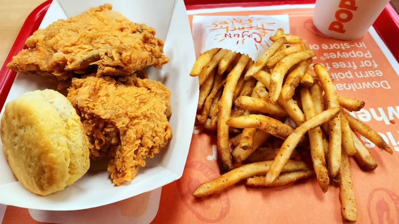Popeyes chicken, biscuit, fries on tray
