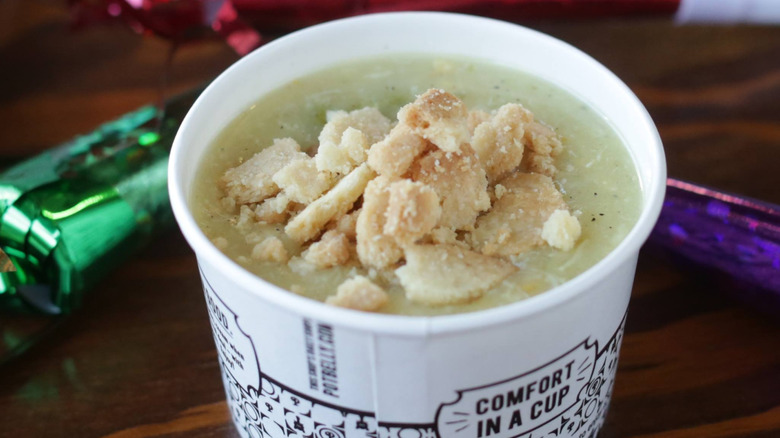 A to-go cup of the Chicken Pot Pie Soup from Potbelly topped with crumbles of pie crust.