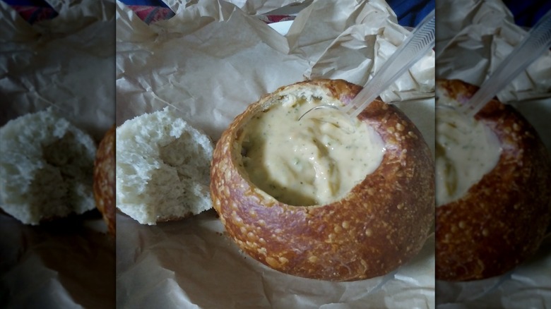 Panera Bread's Broccoli Cheddar Soup in a bread bowl with a spoon sticking out.
