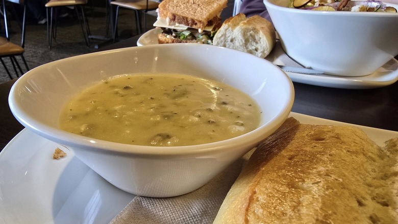 A bowl of Panera Bread's Cream of Chicken and Wild Rice Soup with bread next to it.