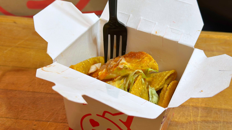 A box of Jack in the Box sauced and loaded tiny tacos with black plastic fork