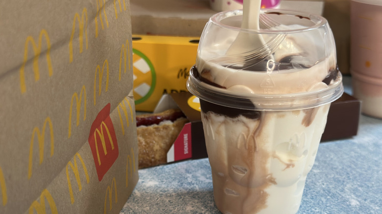 McDonald's chocolate sundae in front of a to go bag