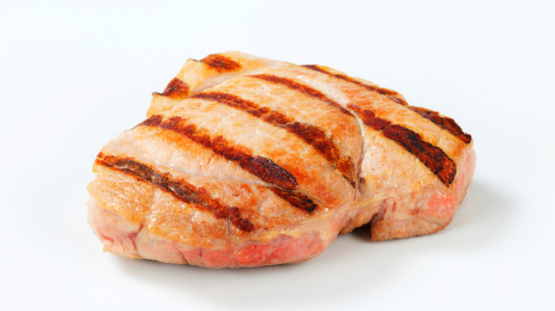 two juicy grilled pork steaks on a white background