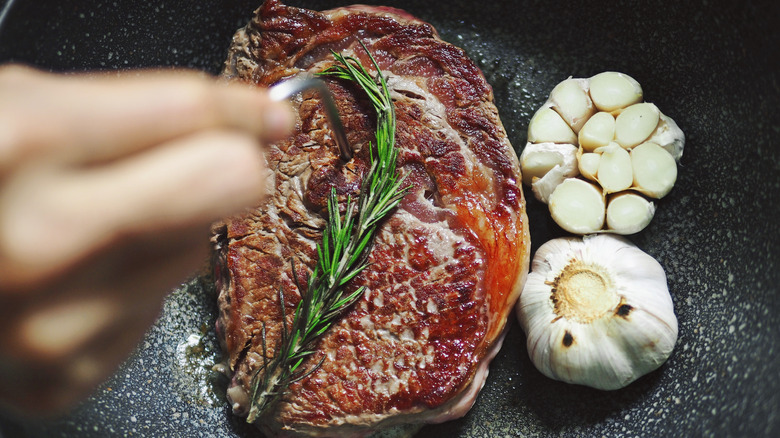using a meat thermometer to check steak temperature