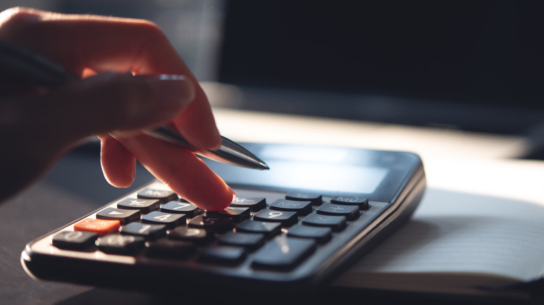 Person using a calculator and notepad