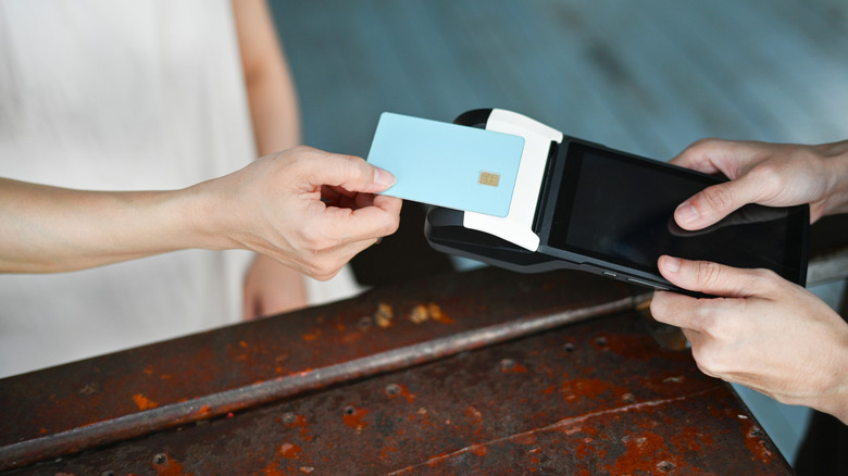 Woman using her card on a point-of-sale system at a restaurant