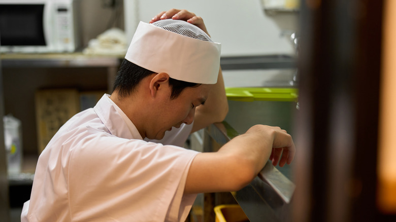 Tired worker takes a break in a restaurant kitchen