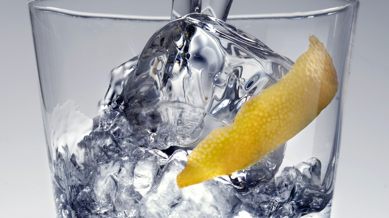 Clear liquid and lemon peel in a glass