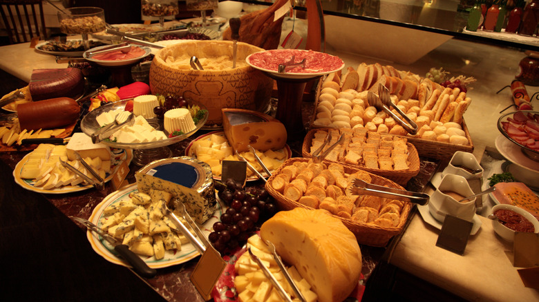 Several types of cheese, bread and meats rest on a self-serve table at a Brazilian Steakhouse.