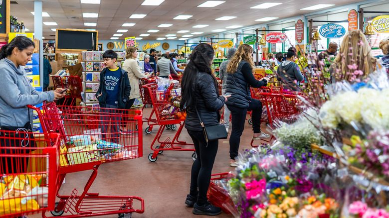 A grocery checkout aisle backed up with shoppers