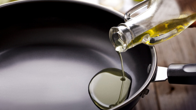 Oil being poured into a frying pan