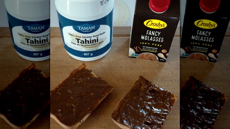 Tahini and Molasses spread on bread. Middle Eastern version of PB&J. with containers or Tahini and Molasses in background