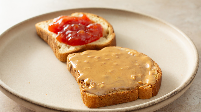 A view of an open peanut butter and guava jelly sandwich.
