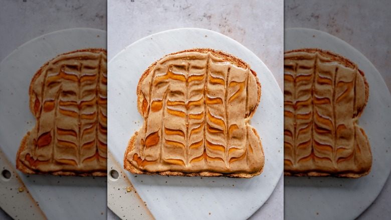 Close up of a toasted bread slice topped with peanut butter and maple syrup swirl