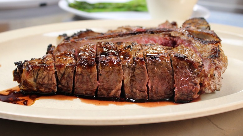 A thick-sliced, juicy steak on a white plate.