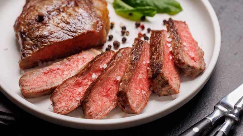 Sliced steak spread on a plate.