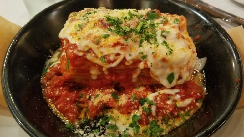 Slice of Romano's Macaroni Grill Lasagna Bolognese on black plate