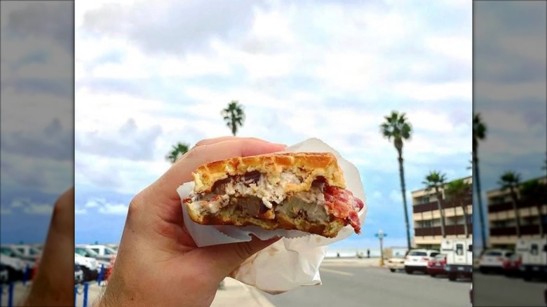 Close up of hand holding hot waffle ice cream sandwich