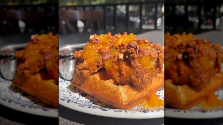 Belgian waffle on plate topped with fried chicken and peach compote