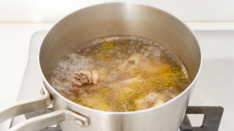 Beef ribs boiling in a stainless steel saucepan