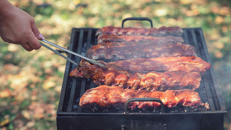 Racks of pork ribs being grilled