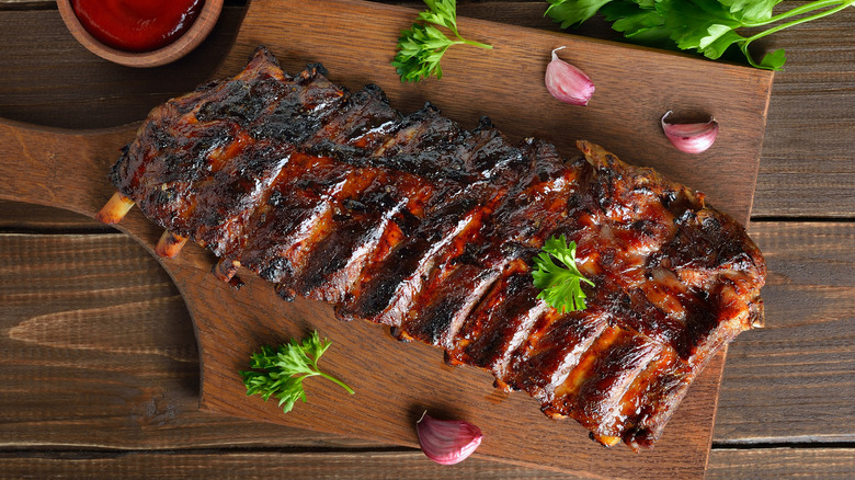 Grilled ribs resting on a wooden board