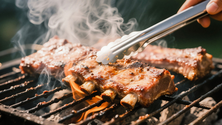 Ribs being grilled with flames and smoke