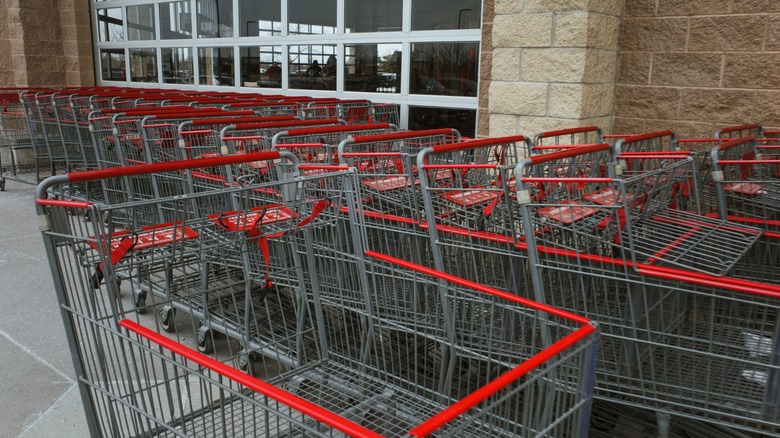 Shopping carts are lined up on the outside of a grocery store