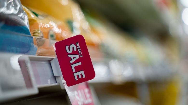 Red sale sign on supermarket shelf in grocery store