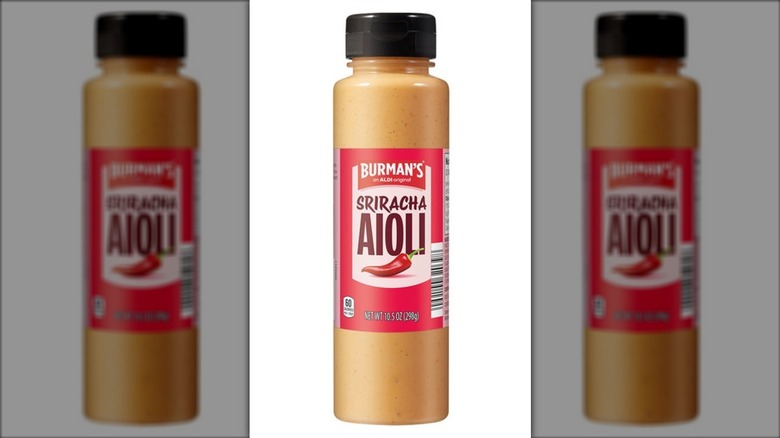 A bottle of Burman's Sriracha Aioli Spread on a white background.