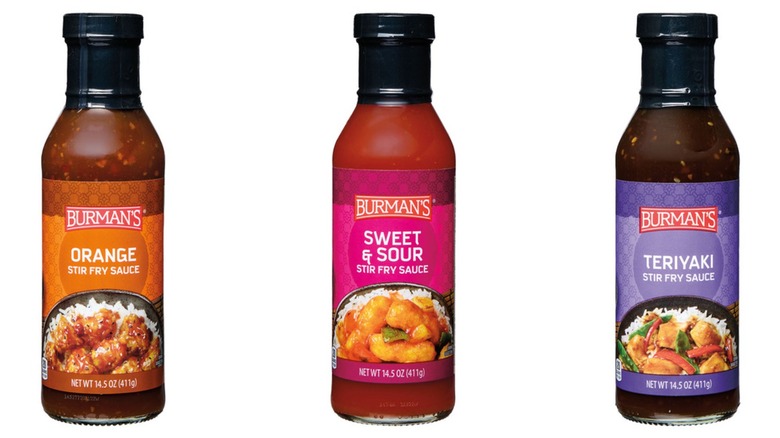 Bottles of Burman's Orange, Sweet & Sour, and Teriyaki Stir Fry Sauces on a white background.