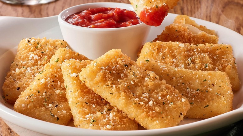 A plate of fried mozzarella with sauce on the side at Olive Garden