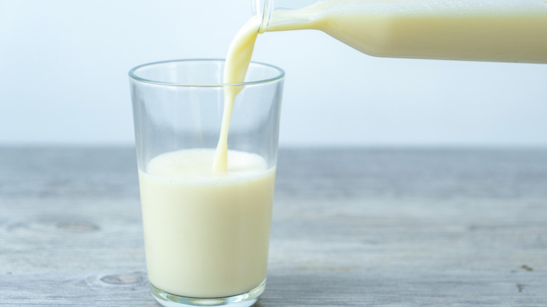 Milk being poured from a bottle into a glass