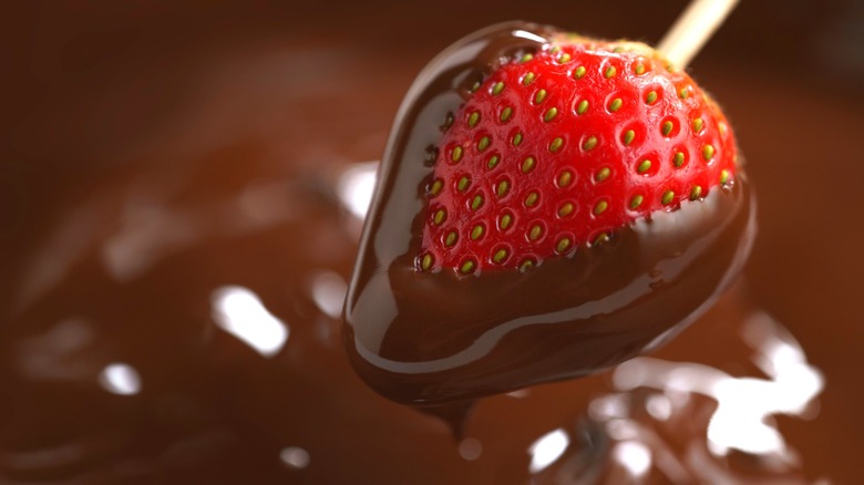 strawberry on a skewer dipped in chocolate sauce