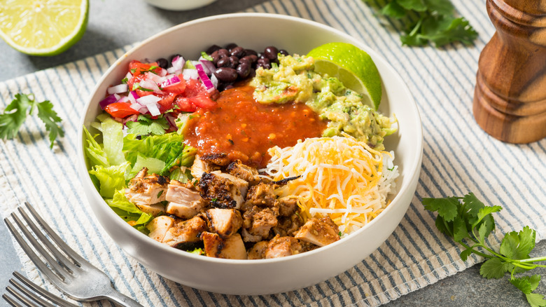 Homemade Mexican burrito bowl with chipotle chicken, cheese, and guacamole