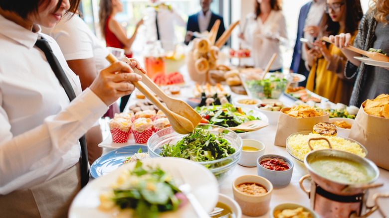People picking salad and food from a lunch buffet