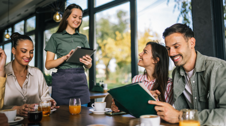 People looking at menus at a restaurant