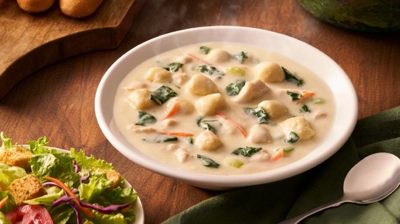 bowl of soup and plate of salad with the tips of two breadsticks at Olive Garden