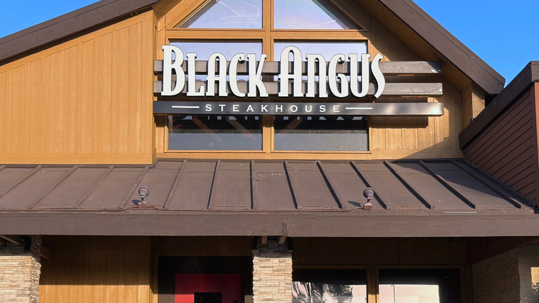 Black Angus Steakhouse storefront against blue sky
