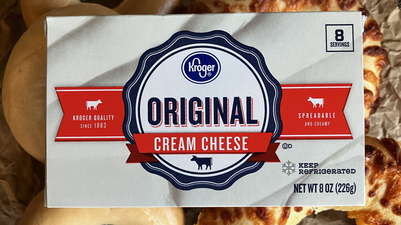close up top view of silver Kroger cream cheese box on top of bagel assortment