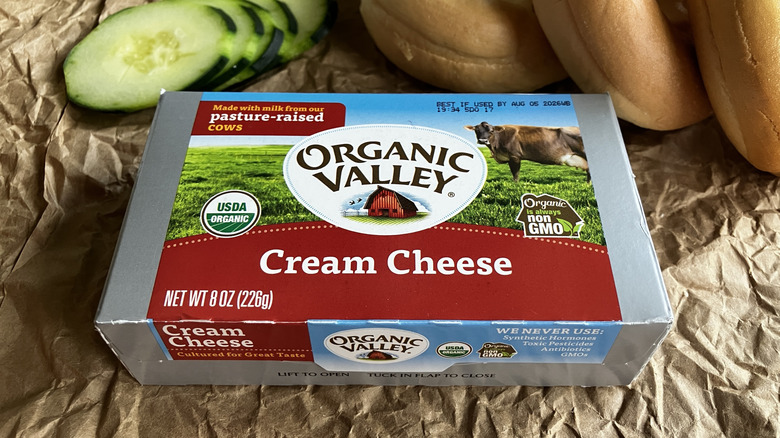 a close up of a box of Organic Valley cream cheese with sliced cucumber and bagels in the background