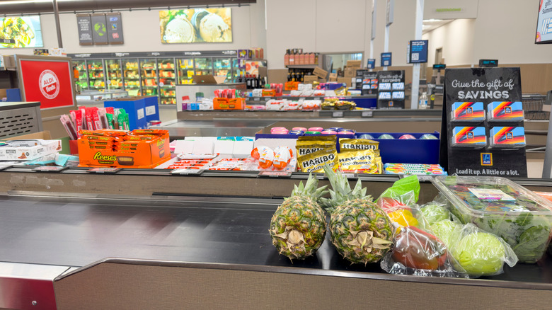 An Aldi checkout aisle with grocery items on the conveyor belt