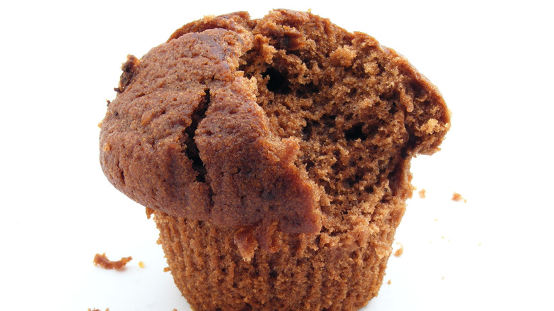 A muffin with a bite taken out of it, isolated on a white background