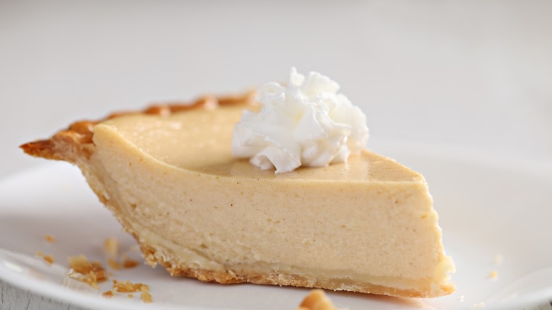 A slice of chess buttermilk pie with whipped cream