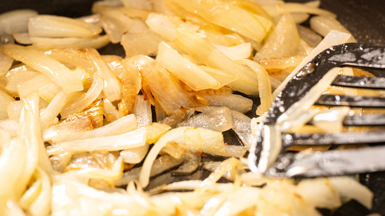 A  close-up of onions frying in a pan