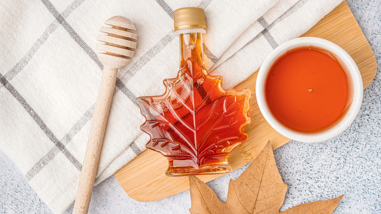 A bottle of maple syrup laying down on table