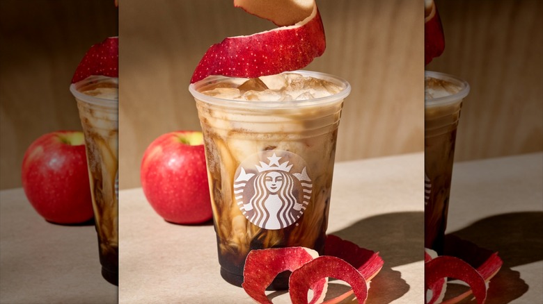 Starbucks Iced Apple Crisp Oatmilk Shaken Espresso with whole apple and apple peel spiral