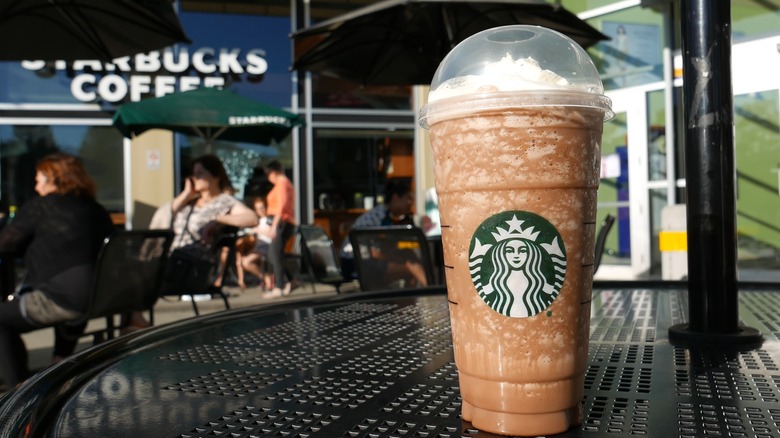 Starbucks blended coffee drink with whipped cream on a table outdoors of the coffee shop